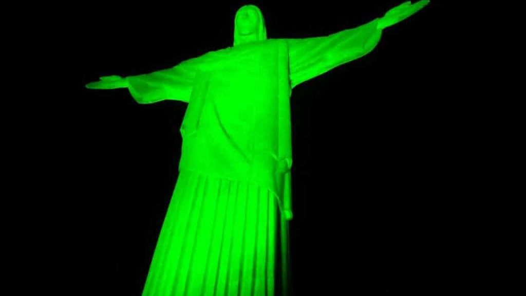 Descrição da imagem: foto do Cristo Redentor iluminado na cor verde.